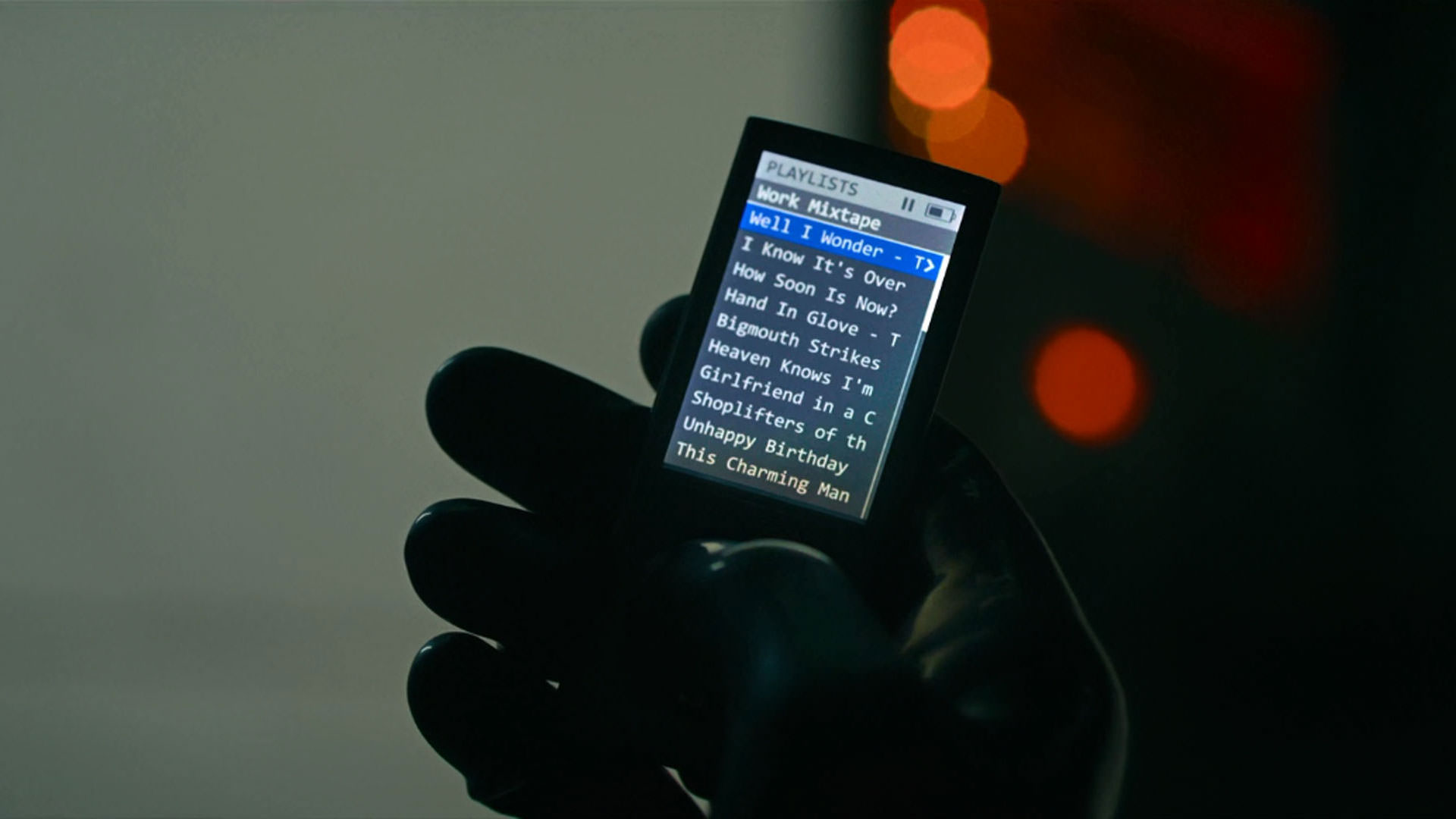 نمایی از یک آیپاد در دستان مردی که دستکشی سیاه پوشیده است در فیلم قاتل به کارگردانی دیوید فینچر
