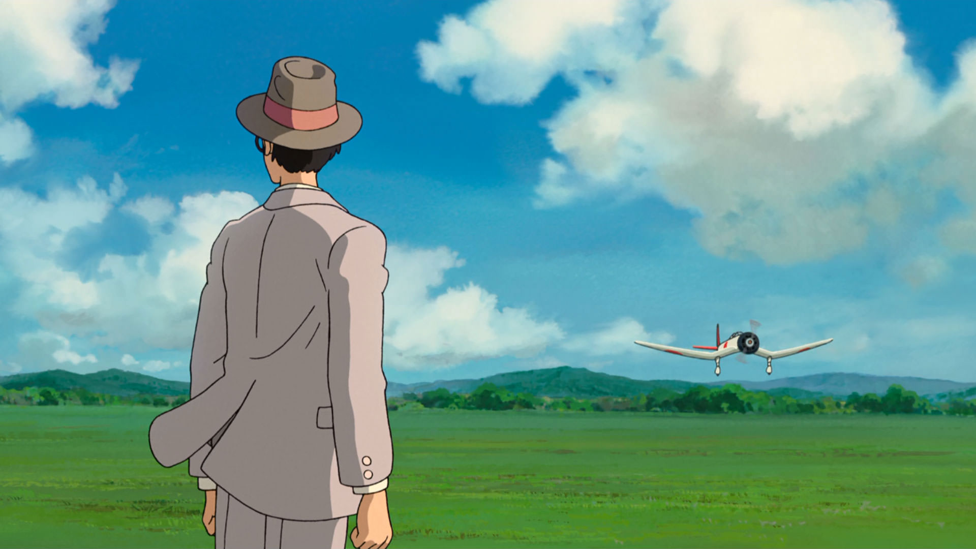 در حالی که یک هواپیما فرود می‌آید مردی به سمت مخالف نگاه می‌کند در نمایی از انیمه باد برمی‌خیزد به کارگردانی هایائو میازاکی