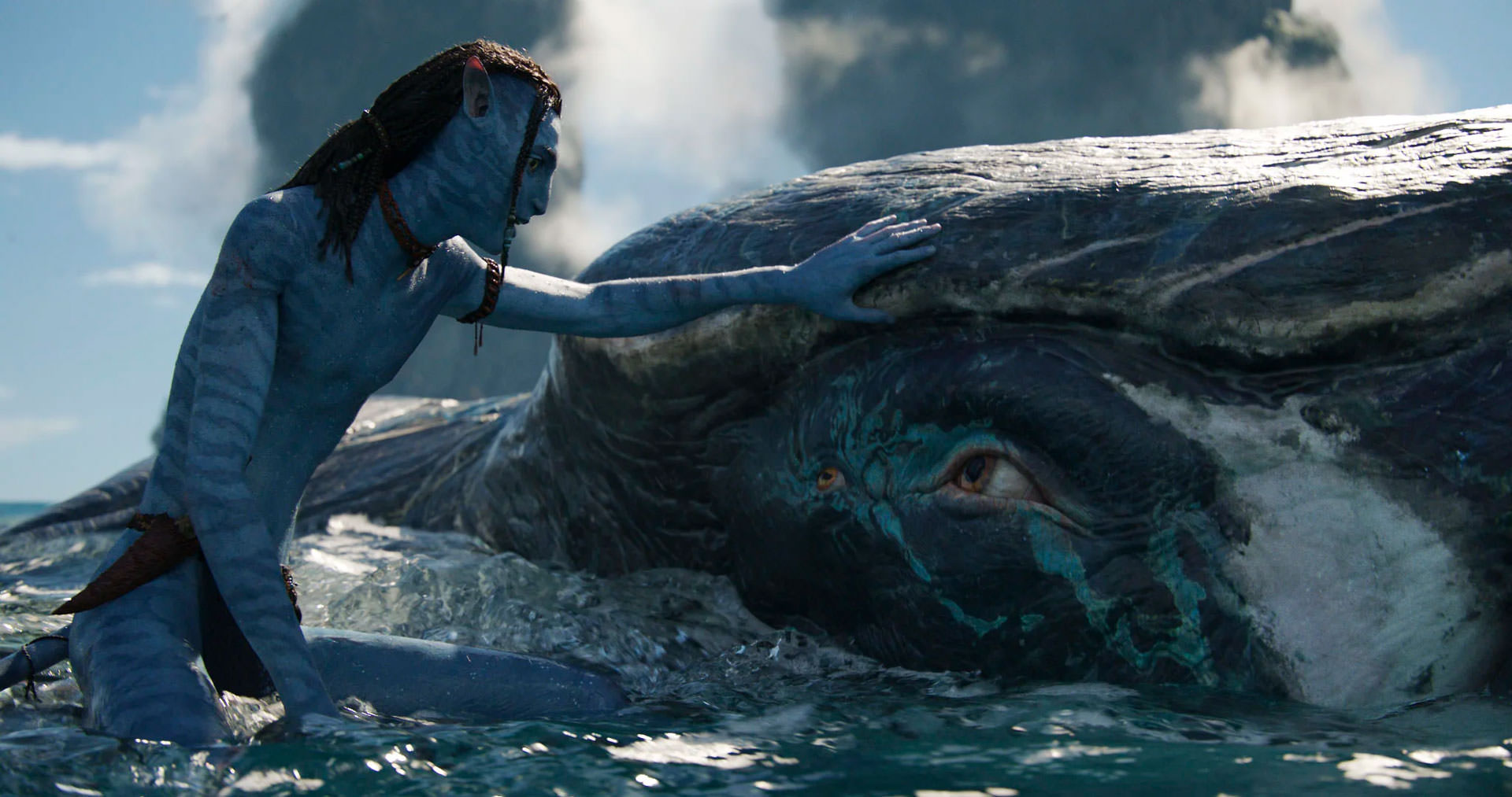 Un adolescent de la race Na'vi à côté d'un animal ressemblant à une baleine appelé Payakan dans une scène du film 