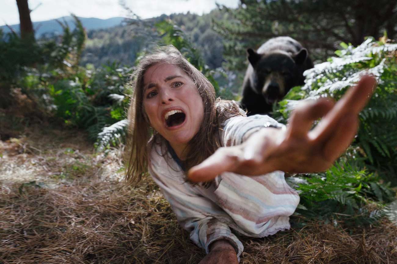 دختری در حال تعقیب توسط یک خرس در فیلم خرس کوکائینی به کارگردانی الیزابت بنکس