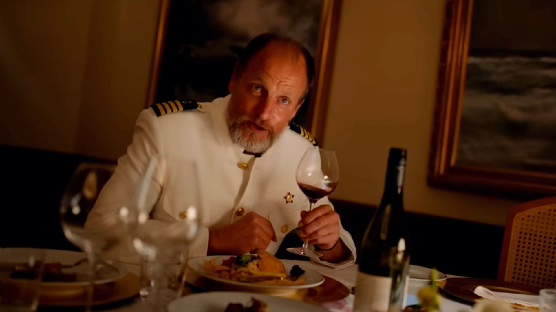 کاپیتان در حال خوردن غذا در فیلم مثلث غم