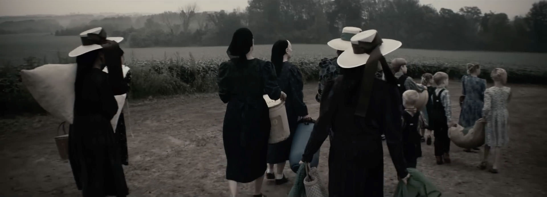 گروهی از زنان تیره‌پوش در حال راه‌رفتن داخل یک مزرعه در نمایی از فیلم حرف زدن زنان به کارگردانی سارا پلی