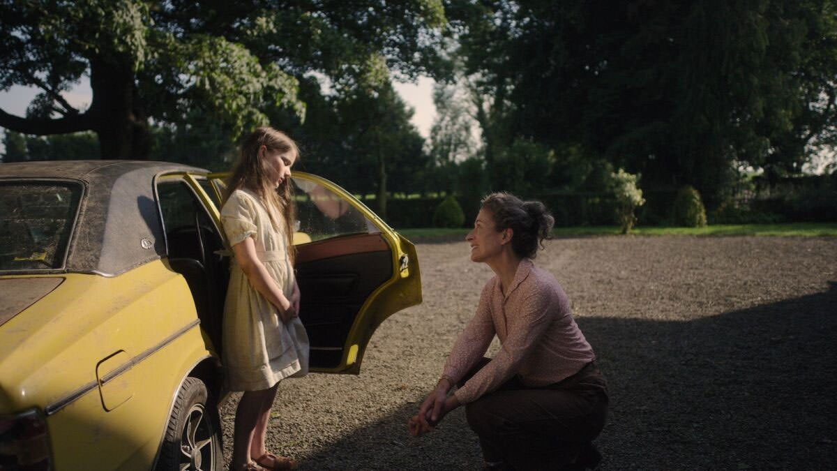 Catherine Clinch debout devant une voiture jaune devant Carrie Crowley dans une scène du film Quiet Girl réalisé par Calum Bari.