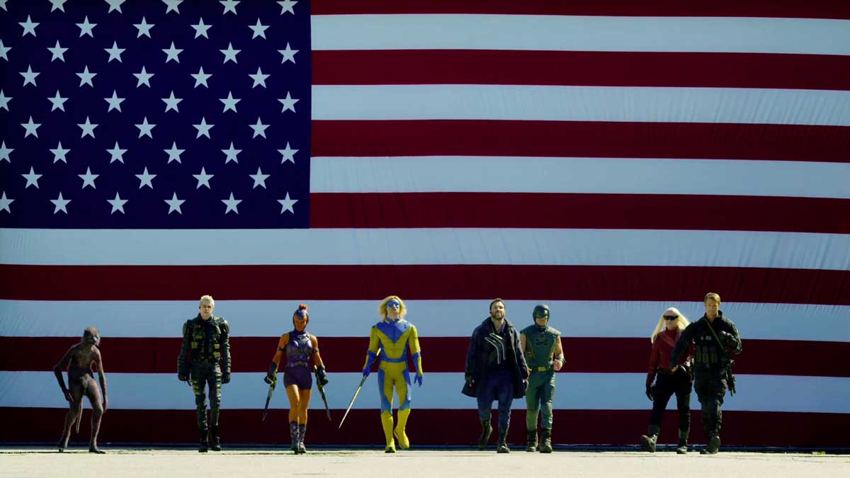 چند عضو جوخه انتحار مقابل پرچم ایالات متحده آمریکا در فیلم The Suicide Squad، یکی از برترین فیلم های ابرقهرمانی تاریخ سینما