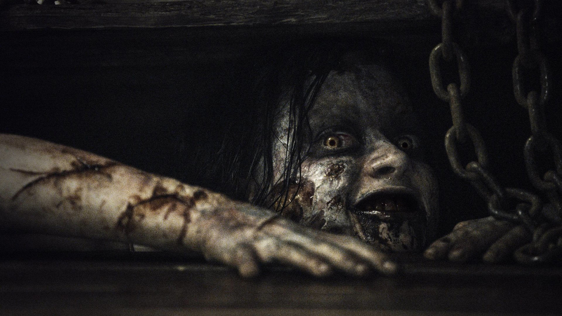 تصویری از دختر ترسناک فیلم مرده شریر یا شیطان مرده که از دریچه زیرزمین بالا کشیده است