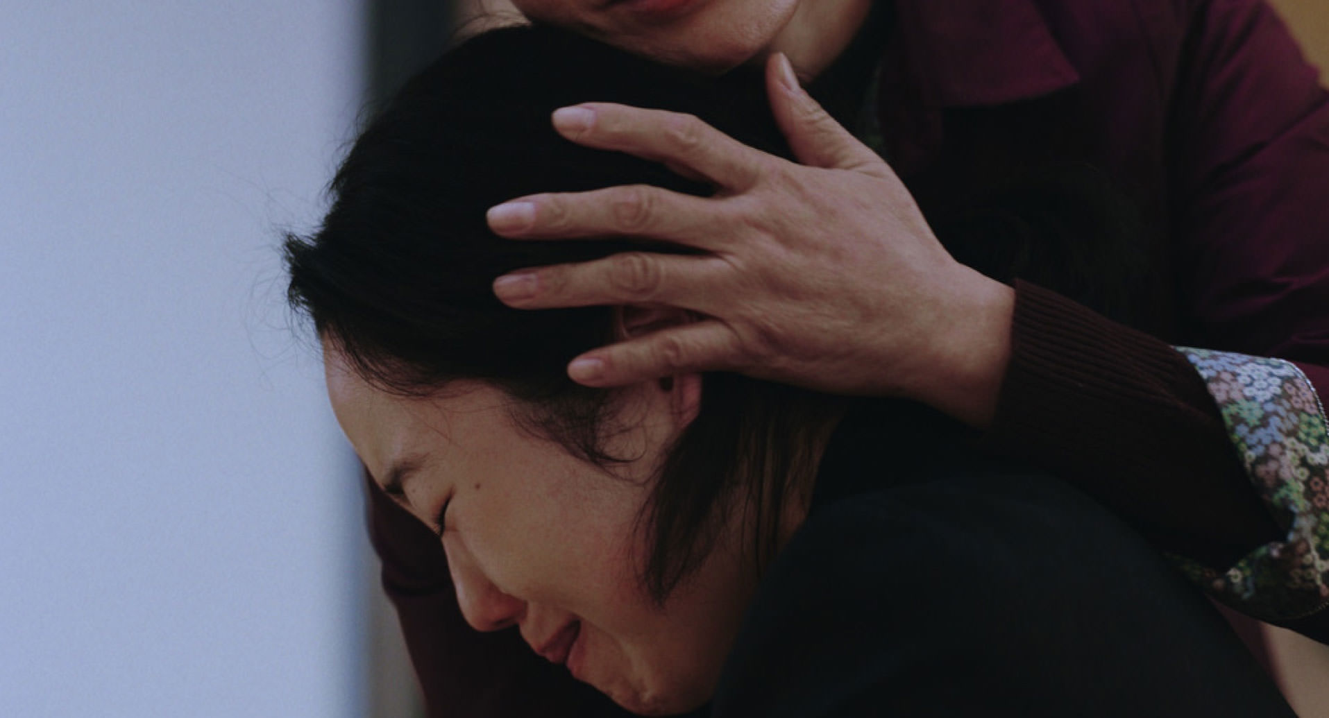 پارک جی-مین در حال گریه کردن در آغوش یک زن مسن در نمایی از فیلم بازگشت به سئول به کارگردانی دیوی چو