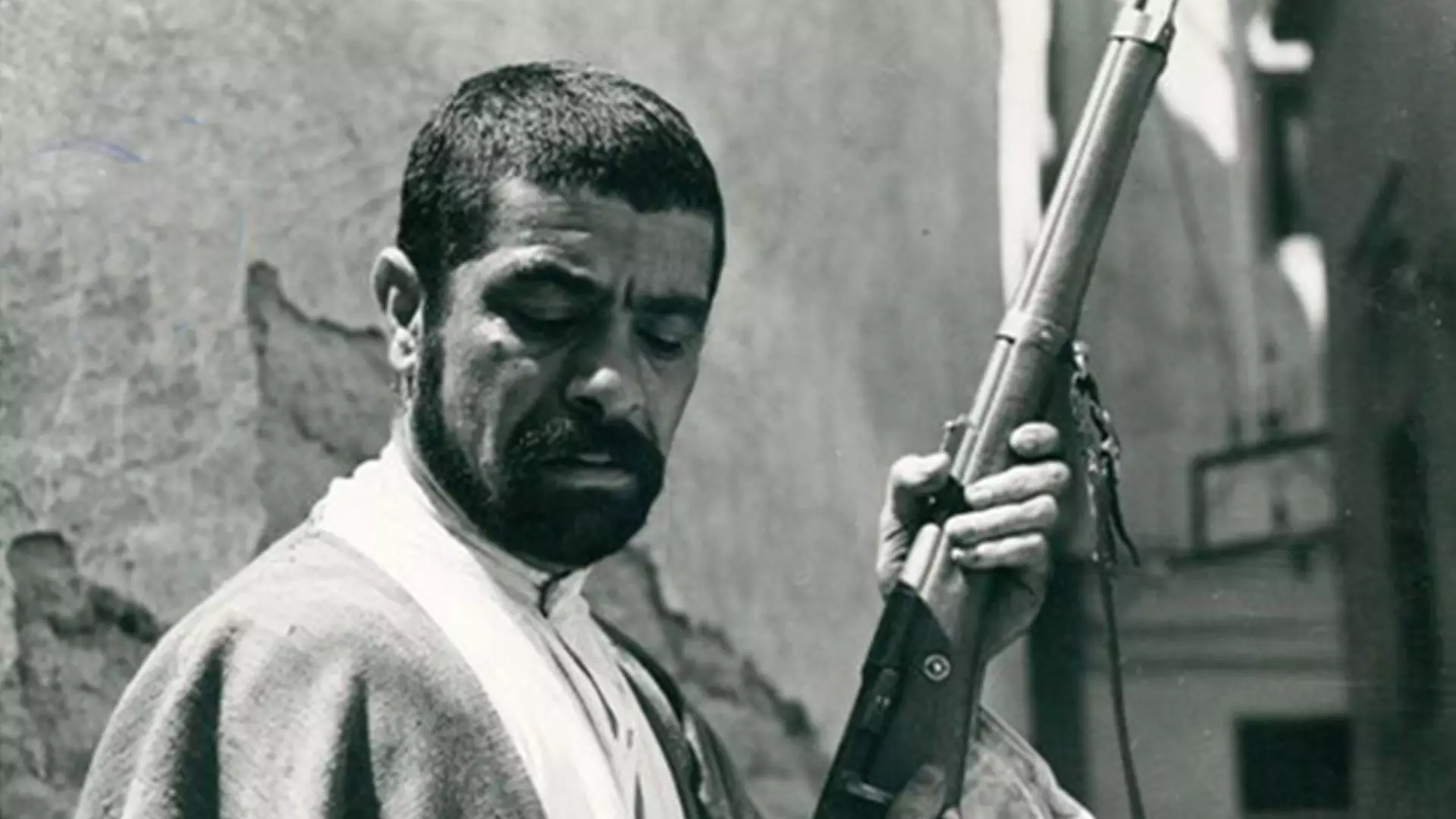زار ممد در حال پاک کردن تفنگ در فیلم تنگسیر