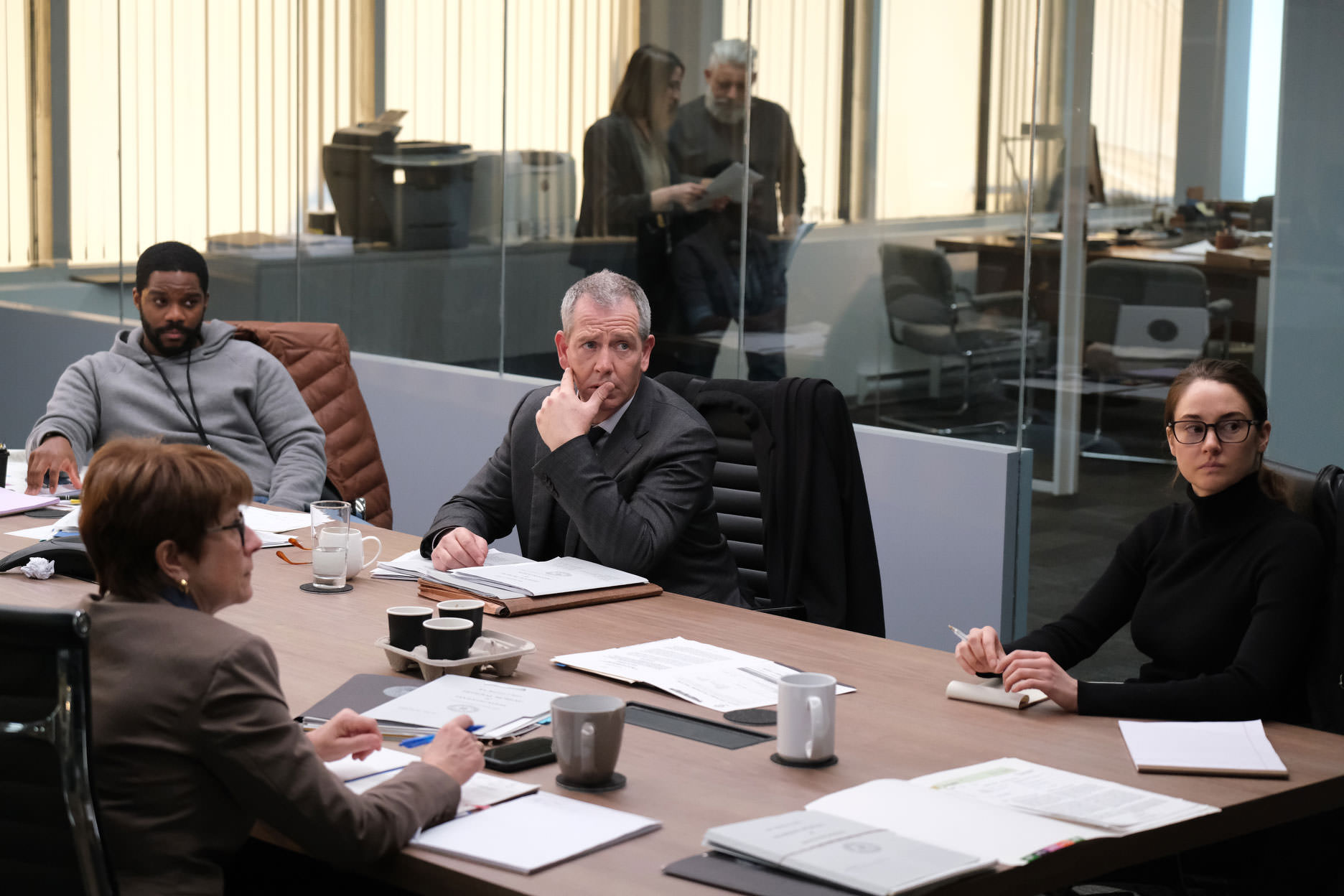 شیلین وودلی، بن مندلسون، و جوان آدپو در کنار چند نفر دیگر نشسته دور یک میز دااخل یک دفتر کار در نمایی از فیلم برای گرفتن یک قاتل به کارگردانی دامیان شیفرون