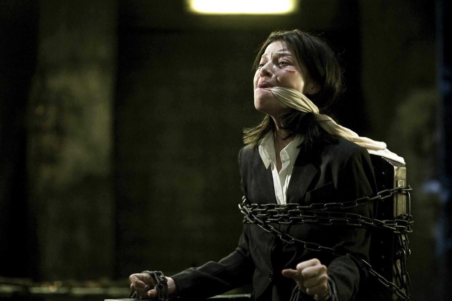 تصویر زنی بسته شده با زنجیر و دهان بسته که شکنجه شده است در فیلم مسافرخانه 2