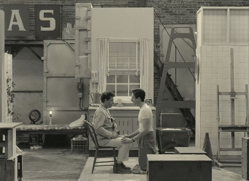 آدرین برودی نشسته روبروی جیسون شوراتزمن در پشت صحنه‌ی یک نمایش در نمایی سیاه و سفید از فیلم استروید سیتی به کارگردانی وس اندرسون