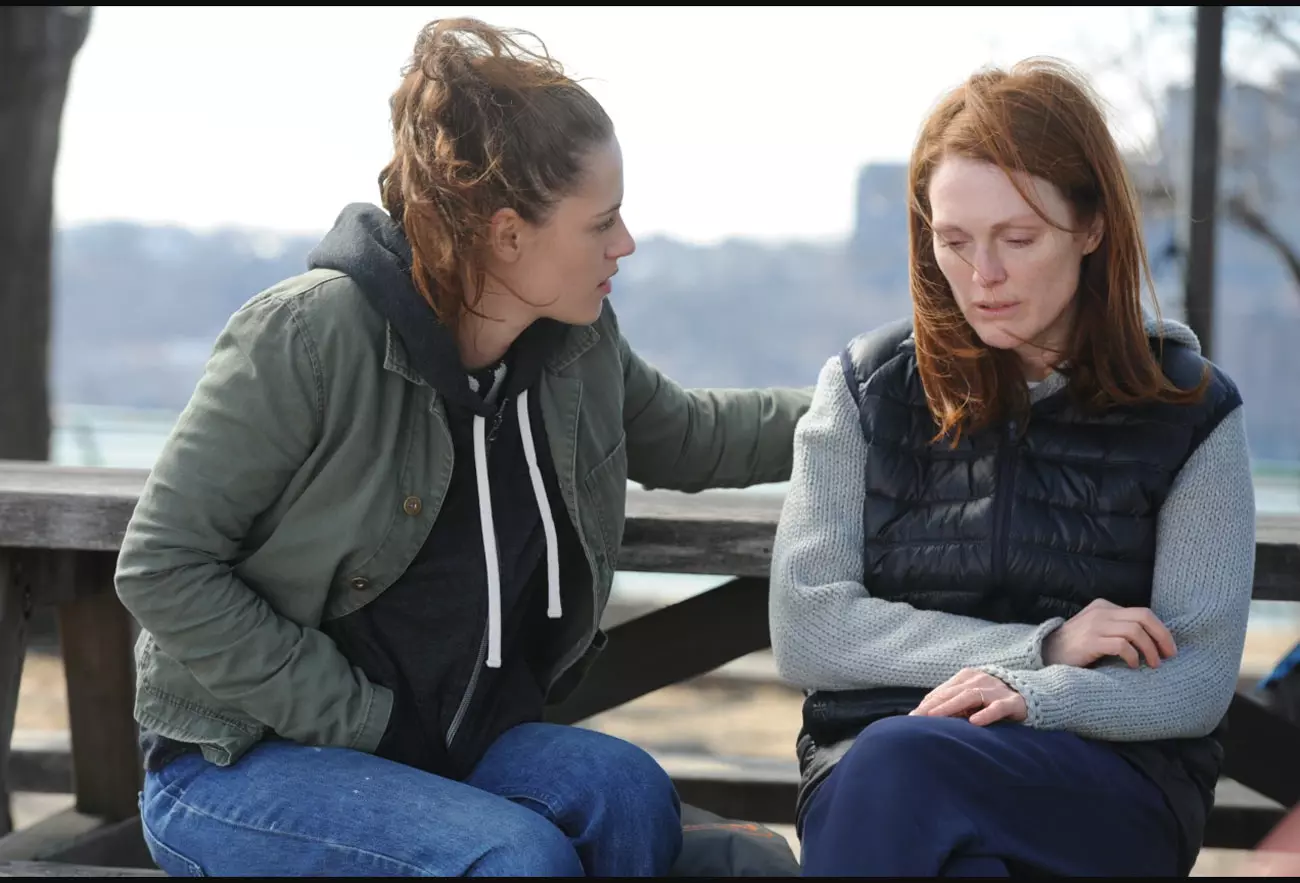 جولین مور و کریستن استوارت در نقش مادر و دختری نشسته روی نیمکت در کنار هم در فیلم هنوز آلیس