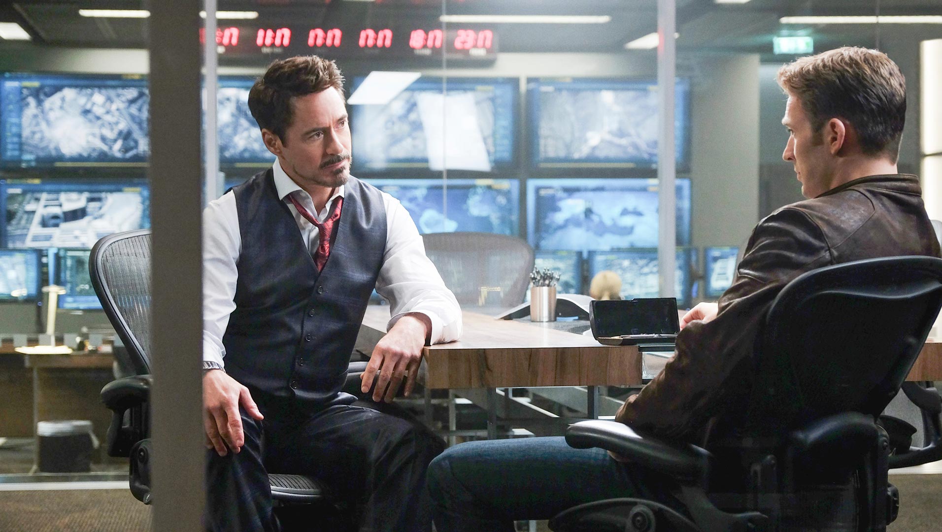 کریس ایوانز و داونی جونیور در نقش کاپیتان آمریکا و مرد آهنی نشسته روبروی هم