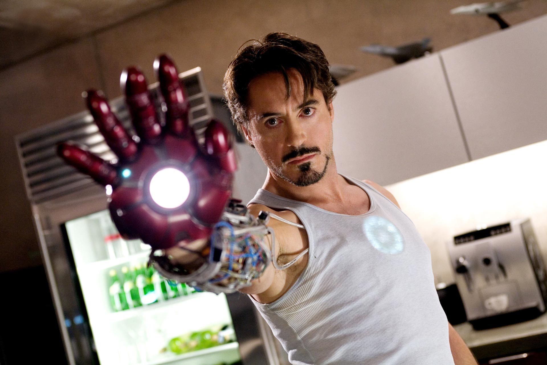 داونی جونیور در نقش تونی استارک در حال امتحان کردن پرتابه لیزری دستکش زره مخصوصش