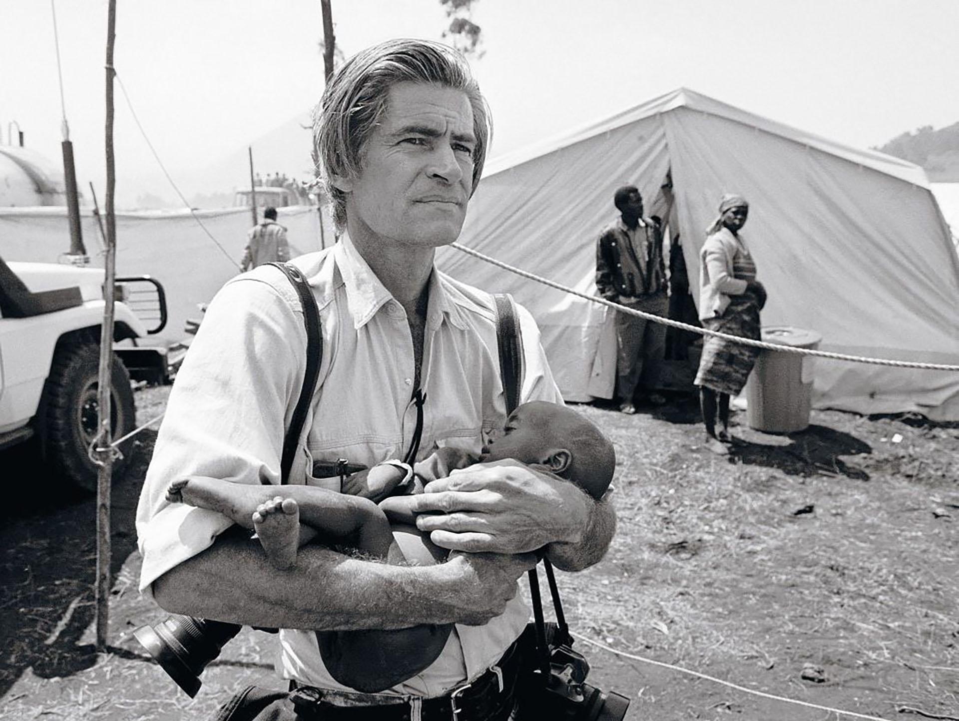جیمز نچوی، عکاس جنگ، کودکی در کمپ جنگی را در آغوش دارد