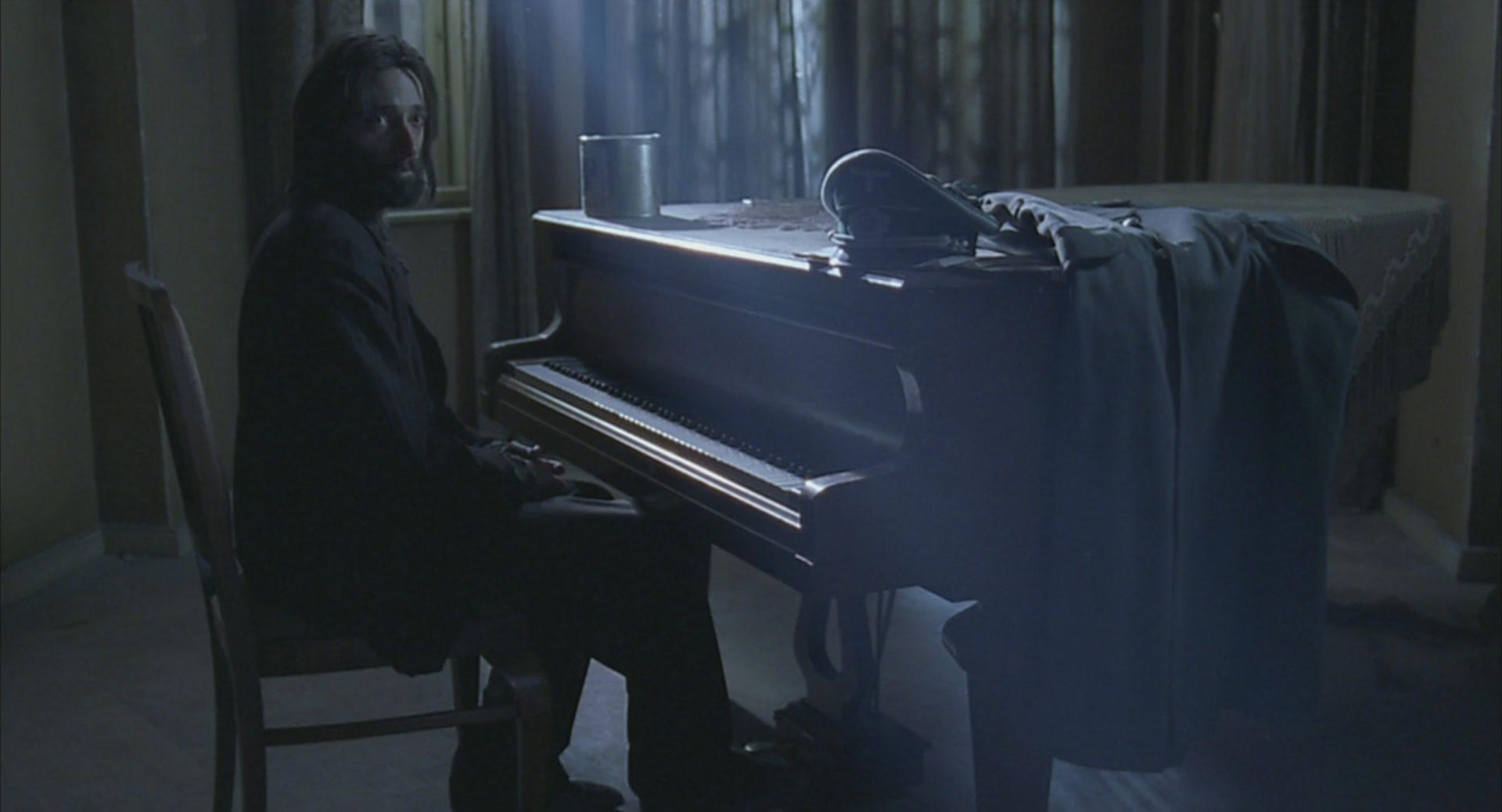 آدرین برودی با چهره ای خسته پشت پیانو در فیلم پیانیست رومن پولانسکی