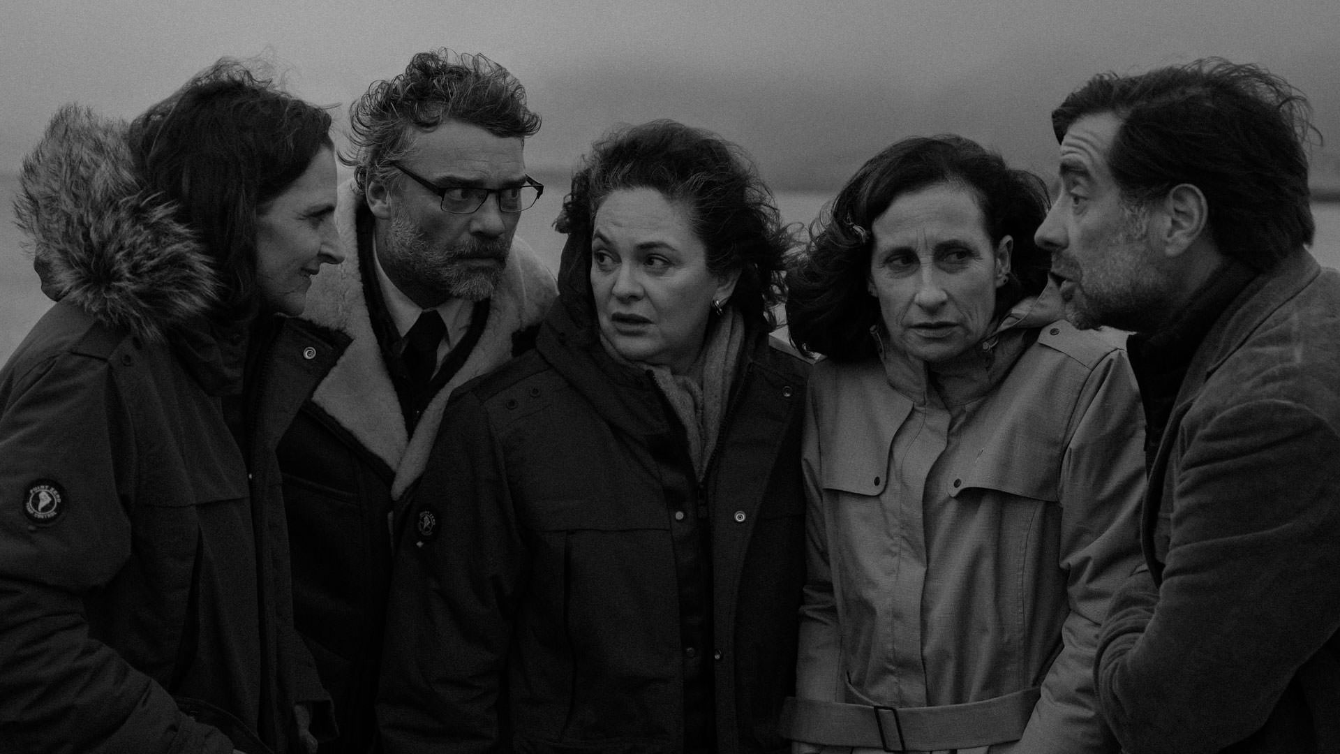 دو مرد و سه زن با لباس‌های گرم در سرما دور هم جمع شده‌اند و راجع به چیزی صحبت می‌کنند در نمایی سیاه و سفید از فیلم «کنت» به کارگردانی پابلو لارائین