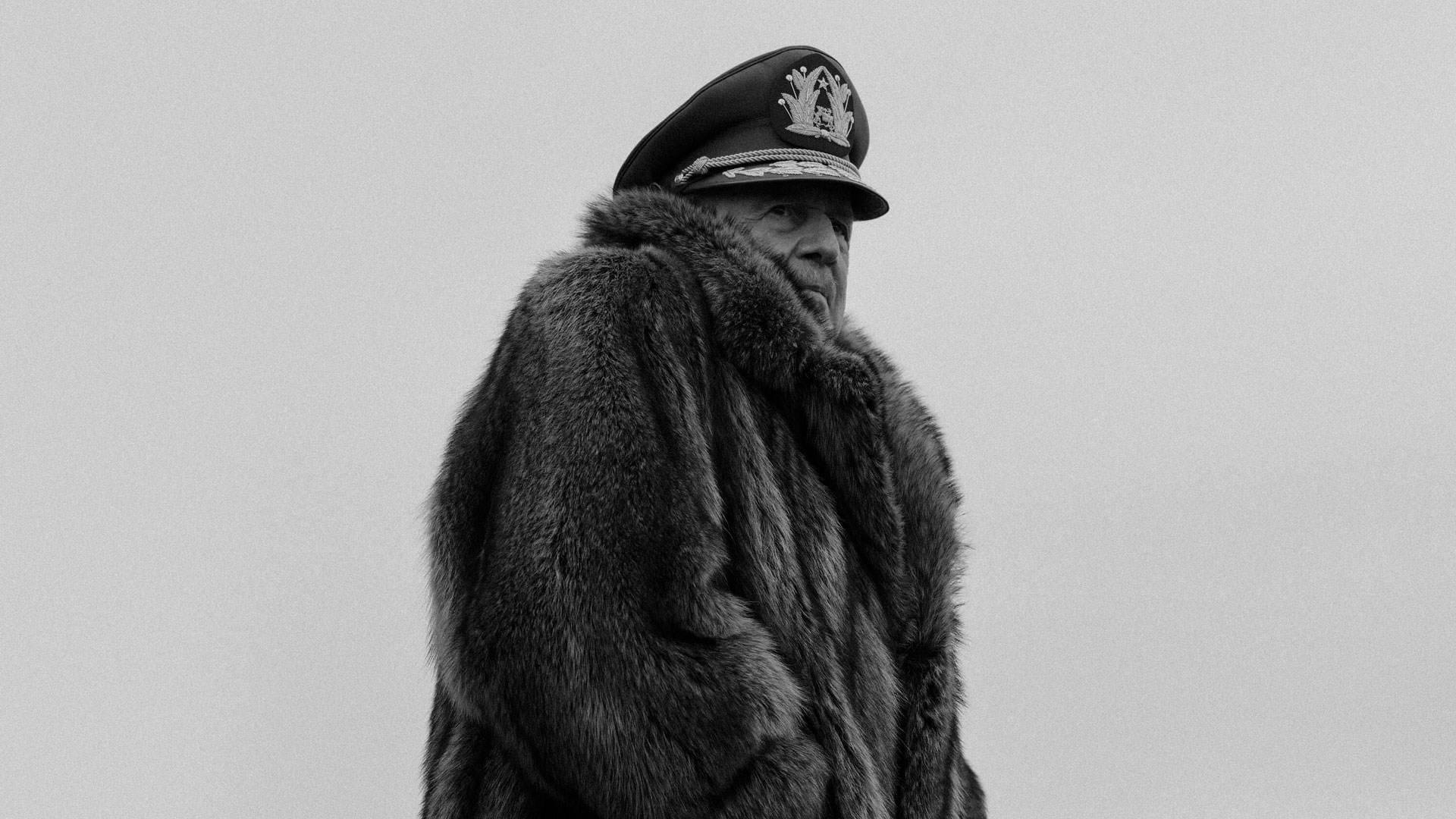 هایمه وادل با لباس گرم و کلاه نظامی در نقش آگوستو پینوشه در نمایی سیاه و سفید از فیلم کنت به کارگردانی پابلو لارائین