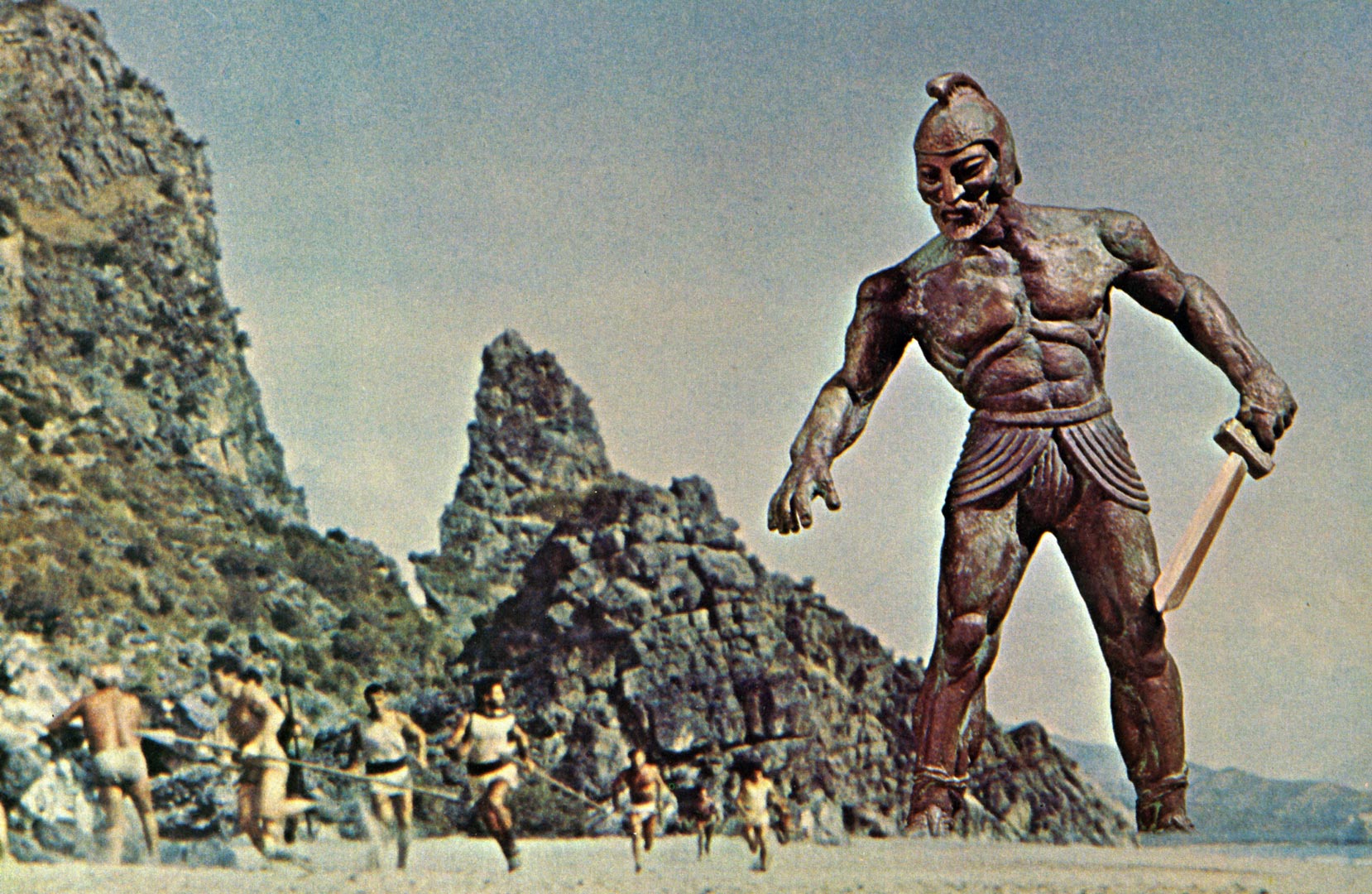 صحنه ای از فیلم جیسون و آرگوناتها که مجمسه بزرگ برنز ی با شمشیری در دست در تعقیب جنگجویان است
