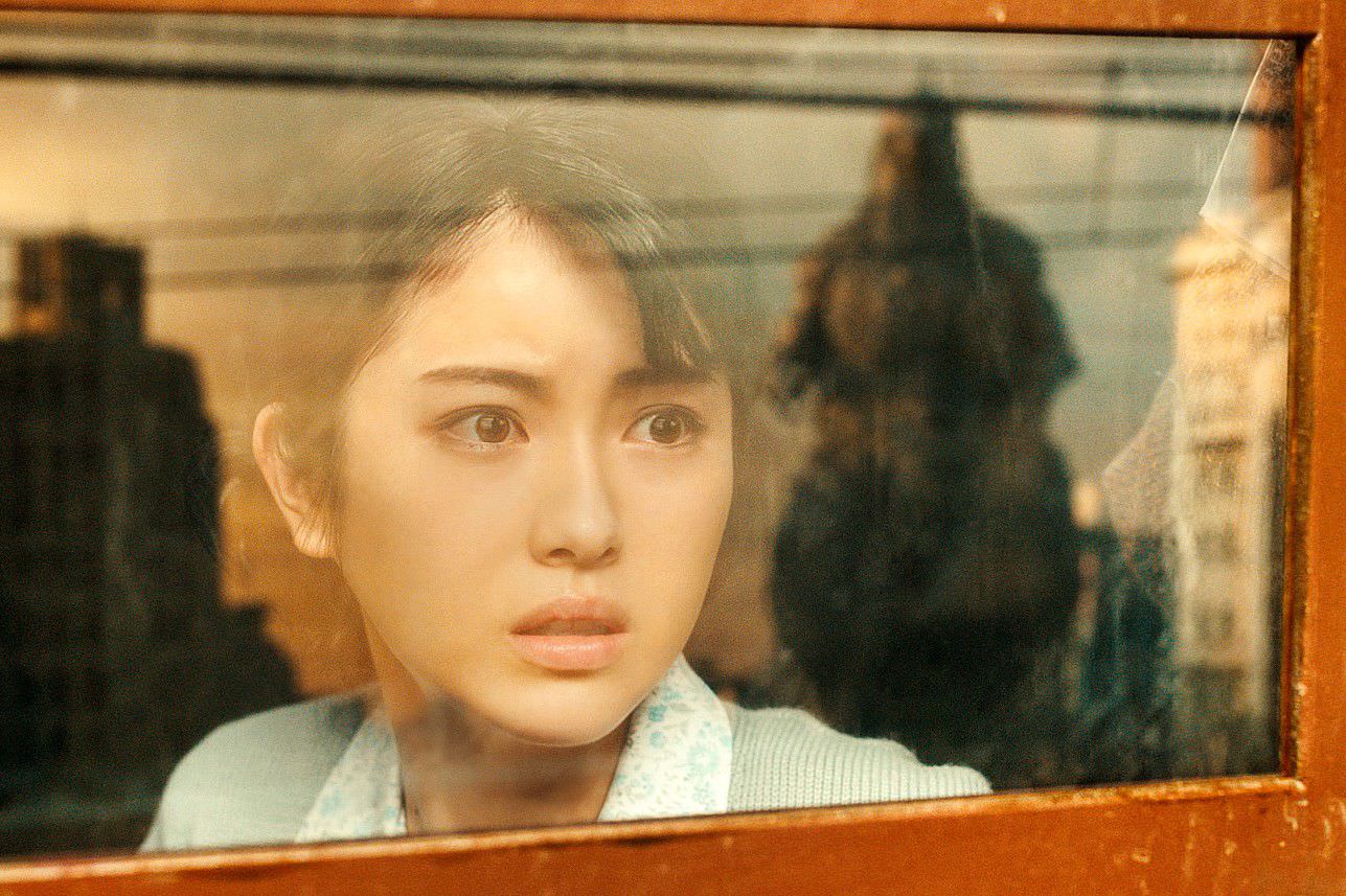 زنی در حال تماشا گودزیلا از پشت پنجره در فیلم Godzilla Minus One