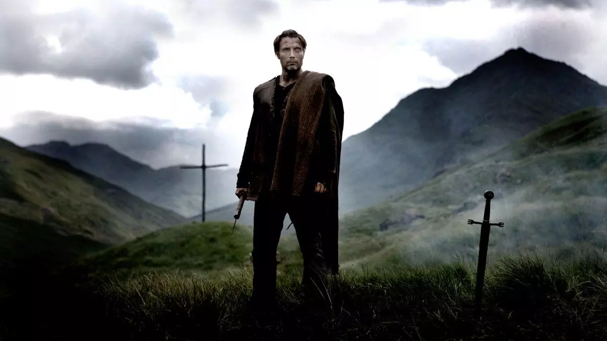 مدس میکلسن در نقش جنگجویی به نام یک چشم در فیلم خیزش والهالا با پس زمینه کوهستان مه آلود