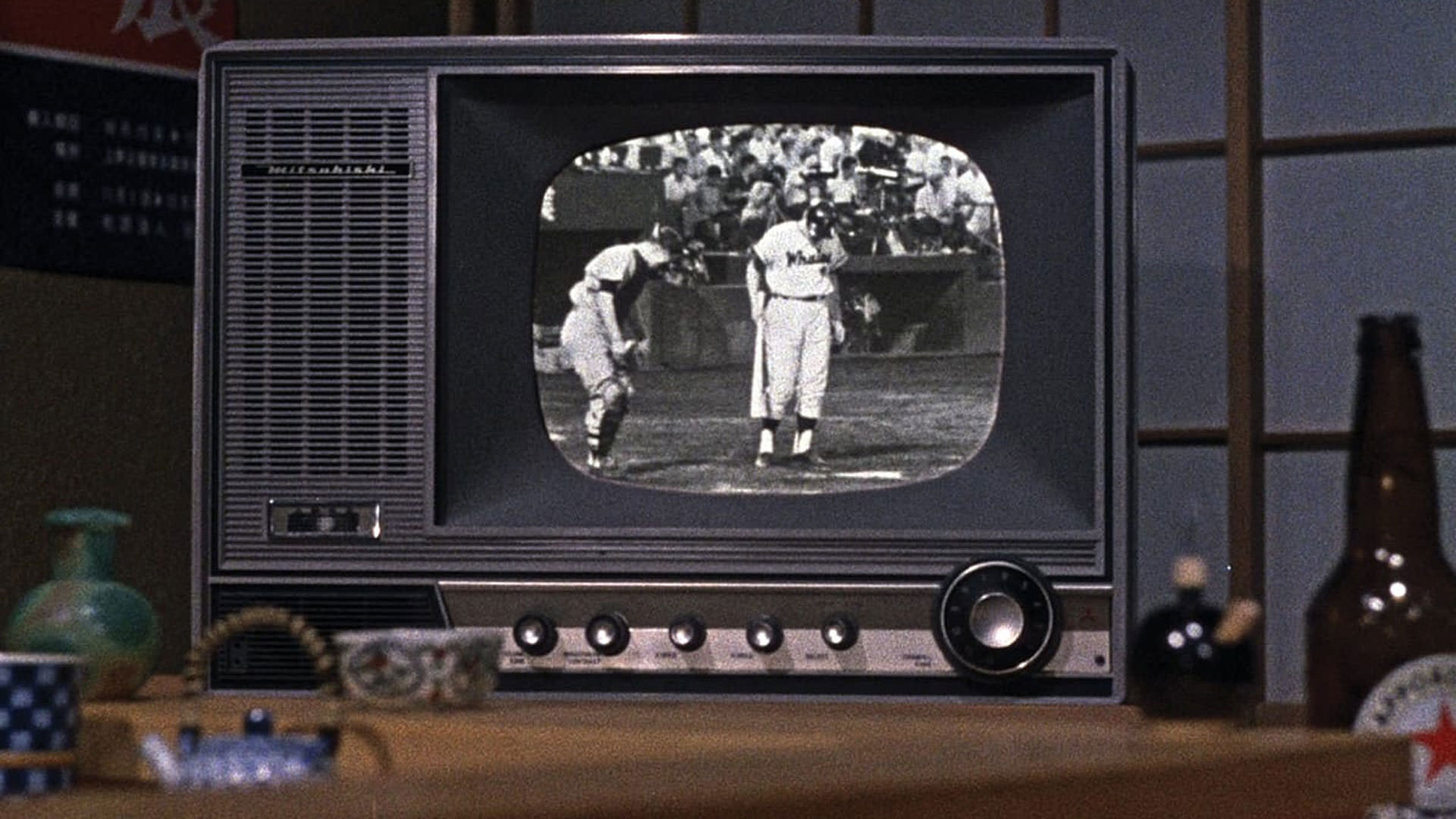 پخش زنده‌ی یک مسابقه‌ی بیسبال داخل یک تلویزیون در نمایی از فیلم یک بعدازظهر پاییزی به کارگردانی یاسوجیرو ازو