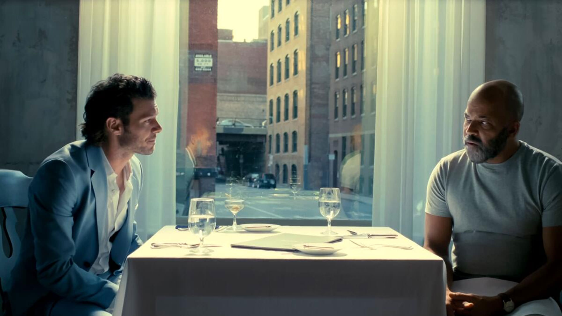 جفری رایت نشسته مقابل آدام برودی در نمایی از فیلم داستان آمریکایی به کارگردانی کورد جفرسون
