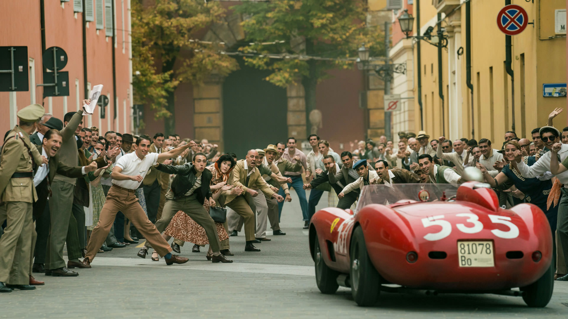 یک اتوموبیل فراری قدیمی در جریان یک مسابقه از میان مردم شهر می‌گذرد در نمایی از فیلم فراری به کارگردانی مایکل مان