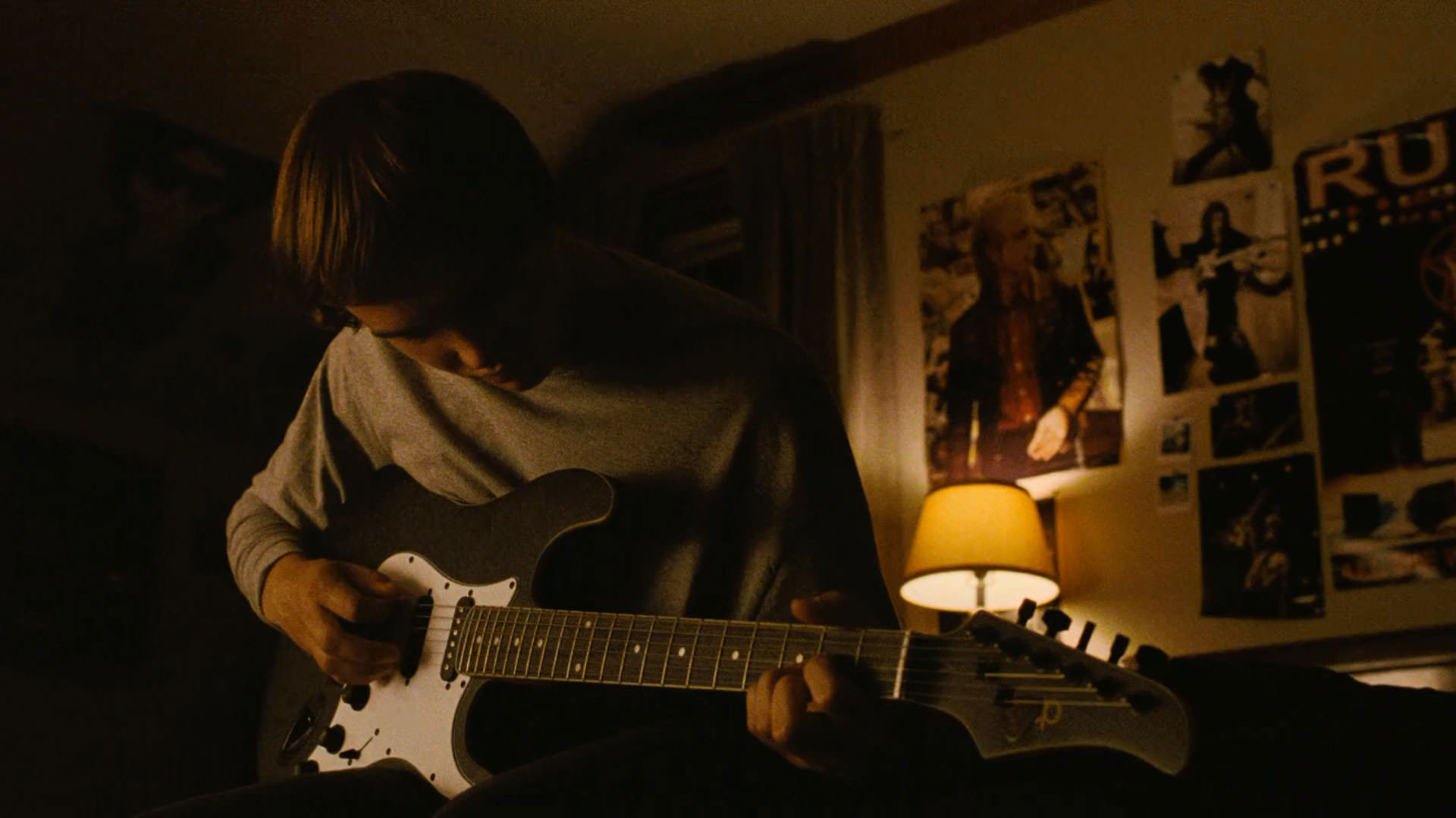 استنلی سیمونز در حال نواختن گیتار در نمایی از فیلم پنجه آهنی به کارگردانی شان دورکین