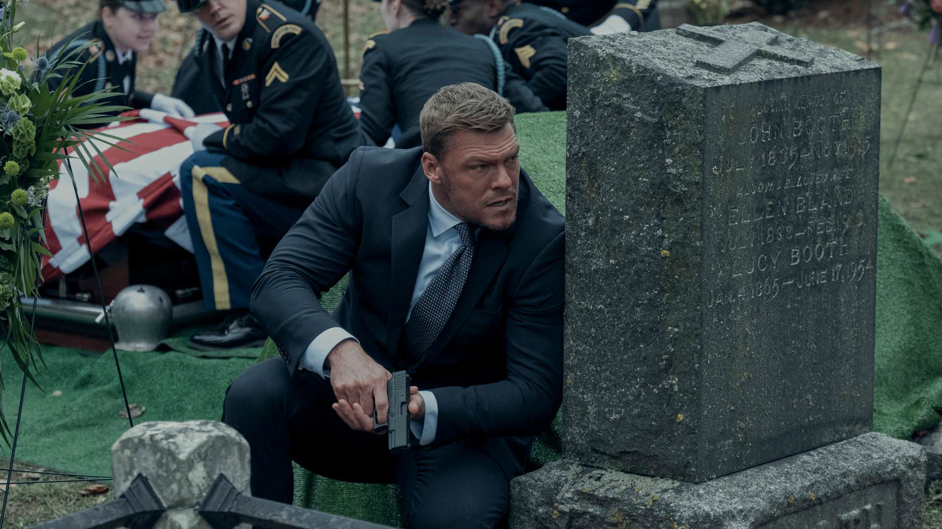 جک ریچر پنهان شده پشت یک سنگ قبر در قبرستان در فصل دوم سریال Reacher