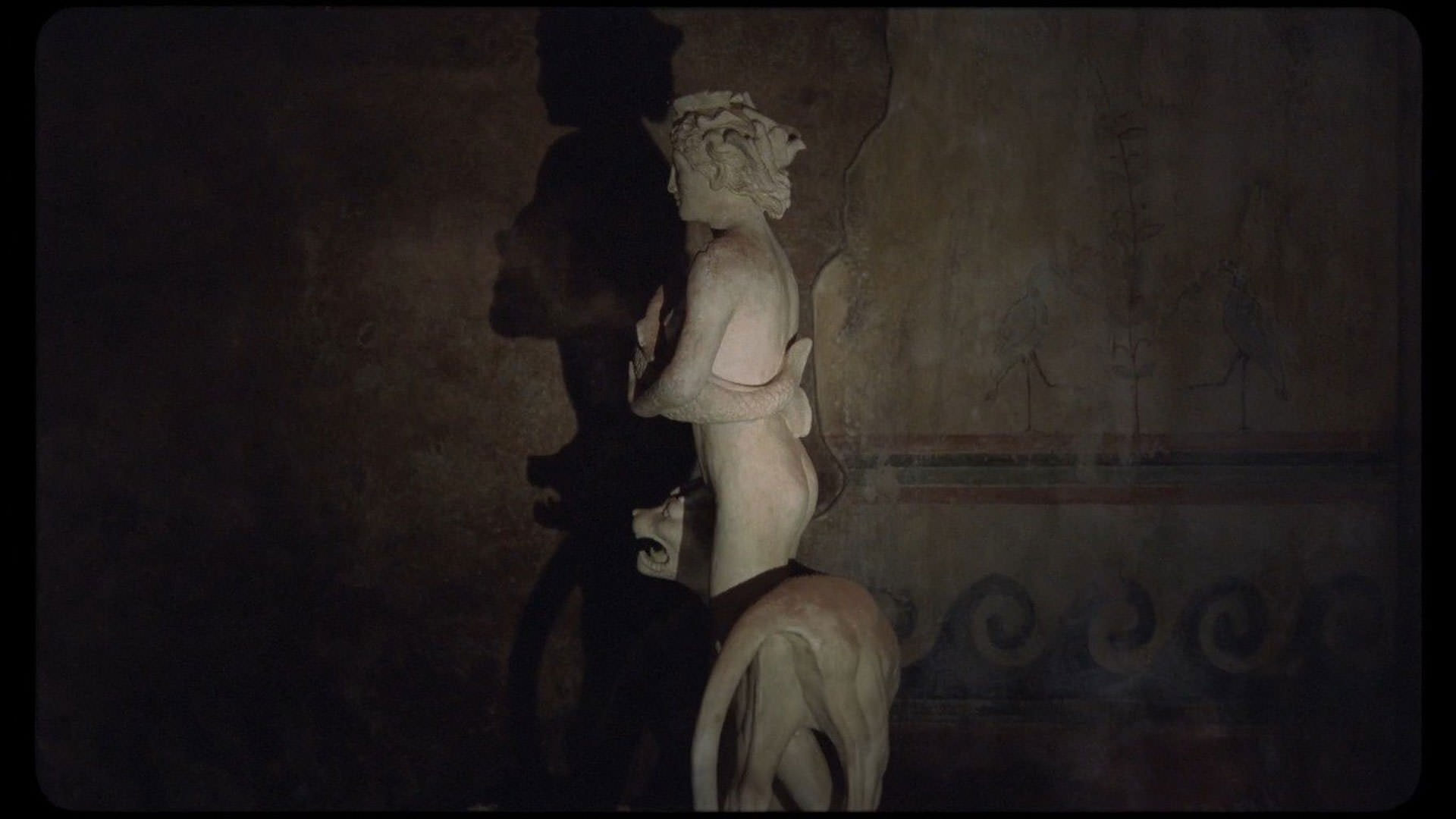 مجسمه‌ای مرمری داخل تاریکی قرار گرفته است و کسی روی آن نور می‌تاباند در نمایی از فیلم کیمرا به کارگردانی آلیچه رورواکر