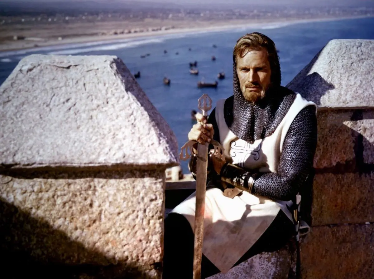 چارلتون هستون در لباس شوالیه های دوران جنگ صلیبی با شمشیری در دست از فیلم ال سید