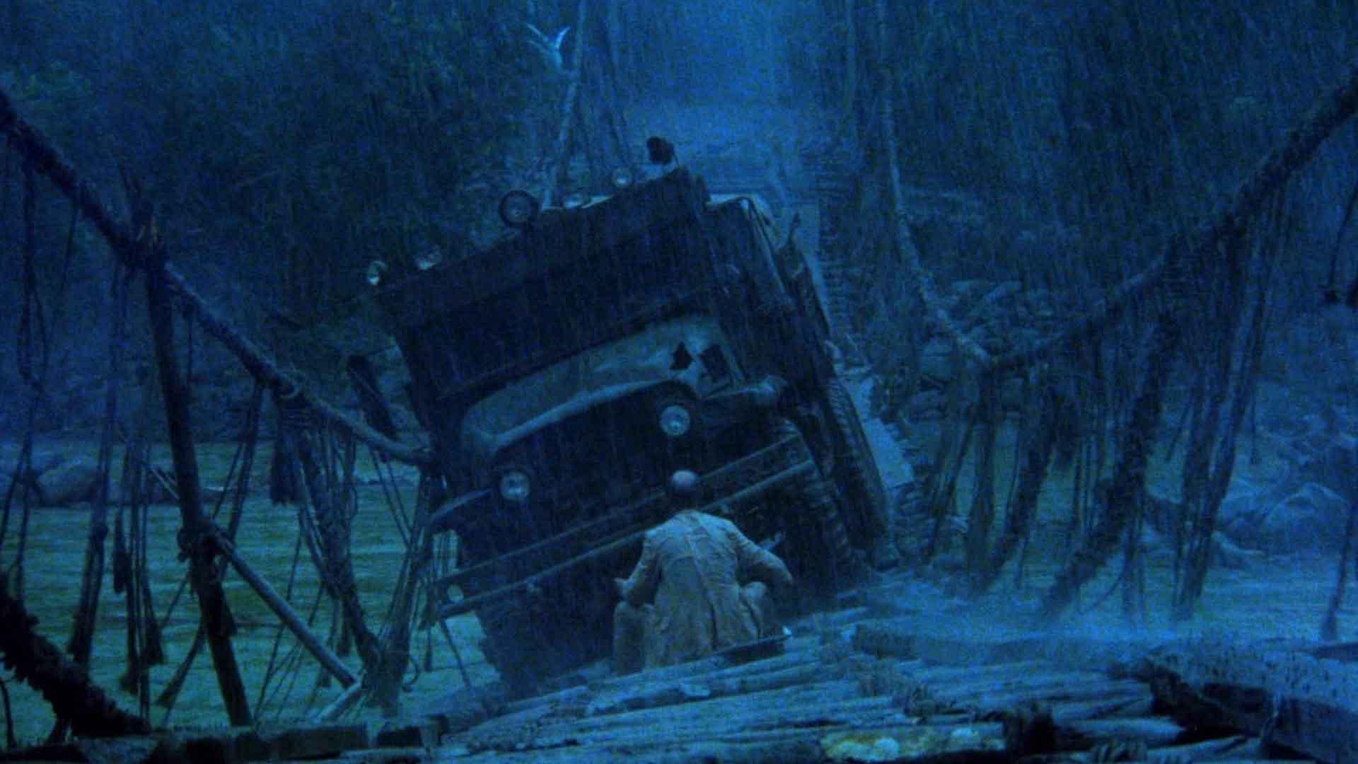 مردی در فیلم Sorcerer روی پل مقابل یک کامیون نشسته است