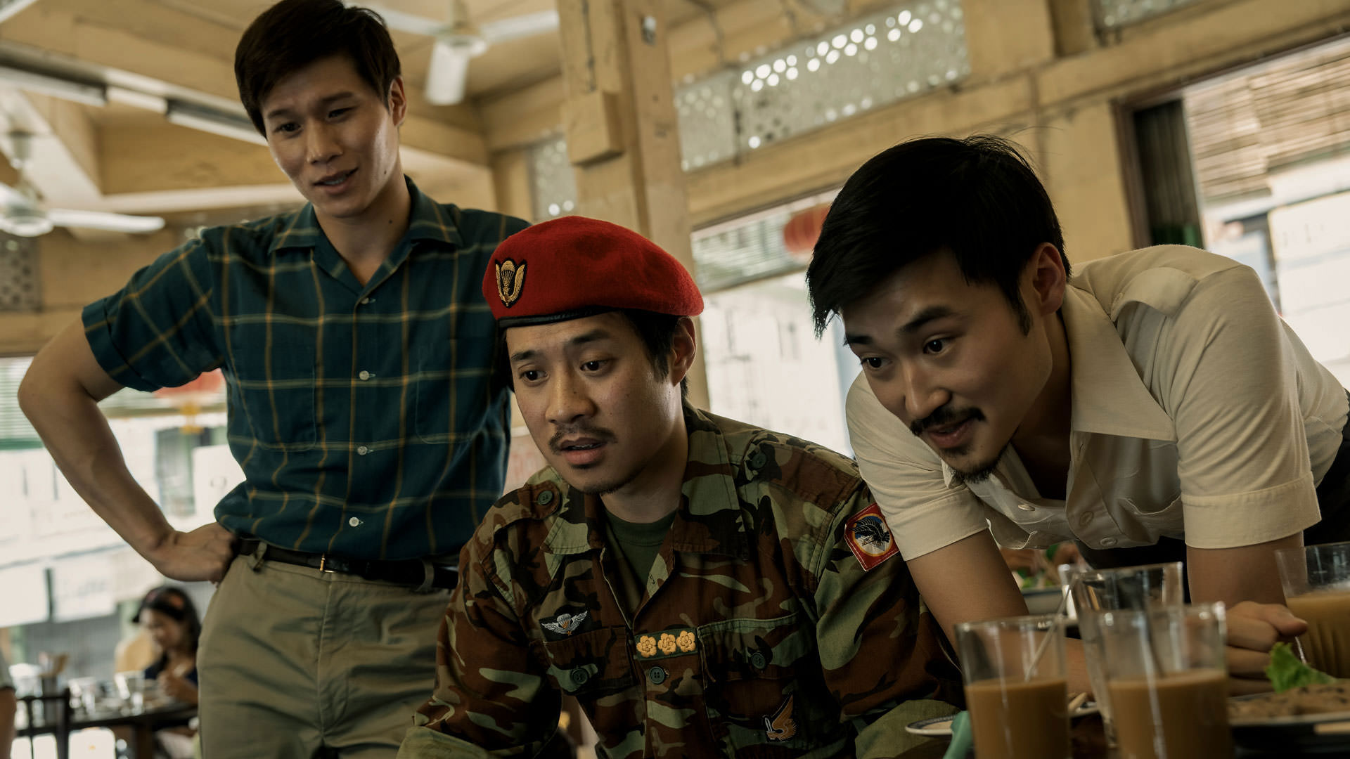 هوئا شوندی و دای نون به روبه‌ور نگاه می‌کنند در حالی که فرد نون خان با لباس فرم نظامی میان‌شان نشسته است در نمایی از سریال هواخواه