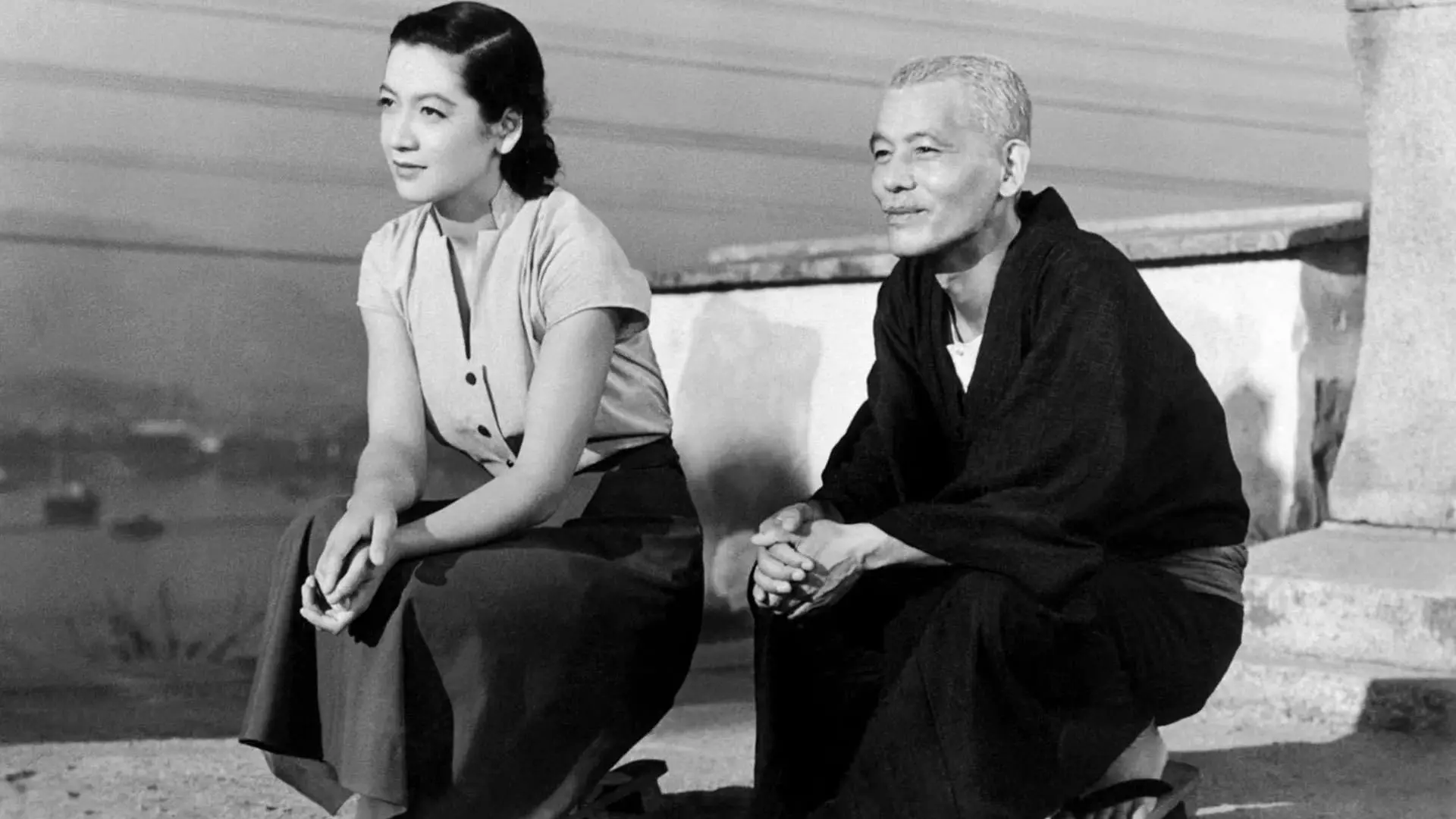 چیشو ریو نشسته کنار ستسوکو هارا در نمایی سیاه و سفید از فیلم داستان توکیو به کارگردانی یاسوجیرو اوزو